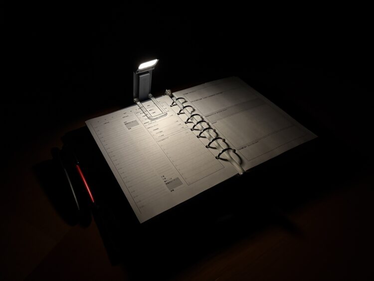 暗闇でglocusent upgrated bookmark book lightの暖色光2700K(5ルーメン)でA5サイズの見開き手帳を照らした様子