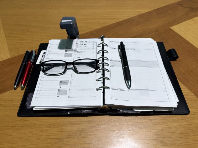 翌日の手帳のデイリーページにglocusent upgrated bookmark book lightを装着し、さらにメガネとペンを置くことで、翌未明の手帳タイムセットになる